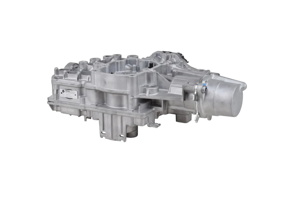 A silver automotive transmission part with a complex, angular metal structure and a cylindrical section at one end, against a plain white background.
