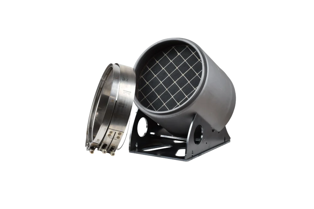 A cylindrical industrial filter with a mesh-pattern front sits on a metal base next to a separately placed metal clamp, all against a plain white background.
